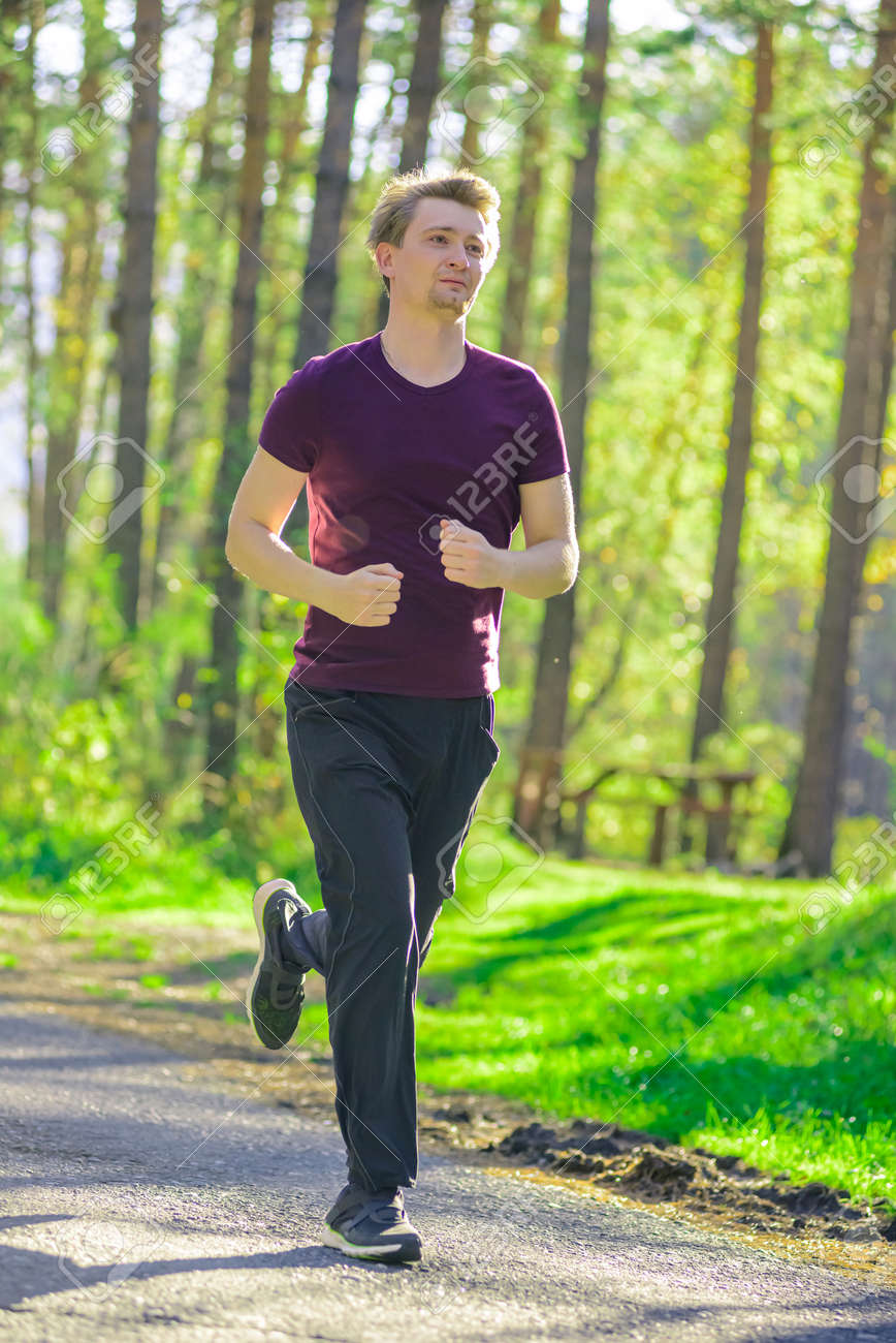 181707506-running-man-jogging-in-city-park-at-beautiful-summer-day-sport-fitness-model-caucasian-ethnicity
